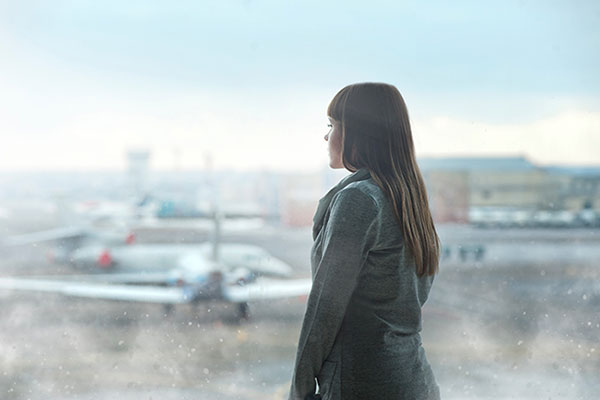 Woman looking out of window at aircraft